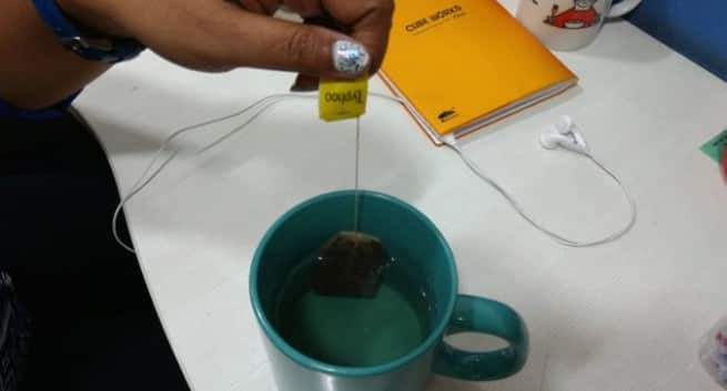 Dipping the tea bag in a hot cup of water.